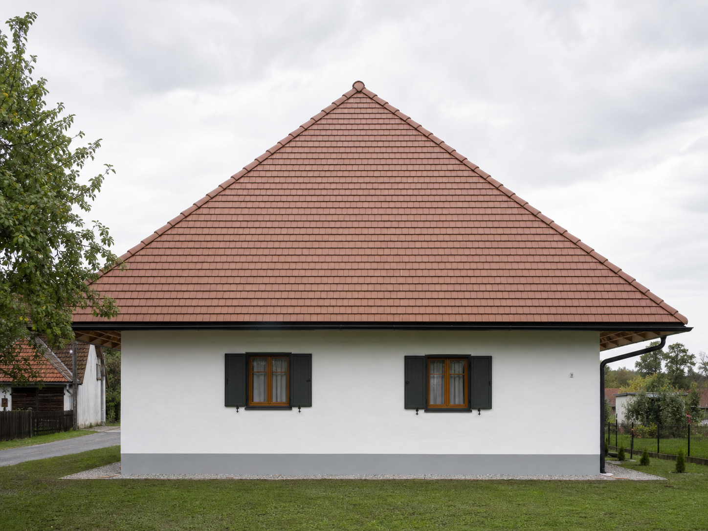 Zaključena fasada na hiši z opečnato streho